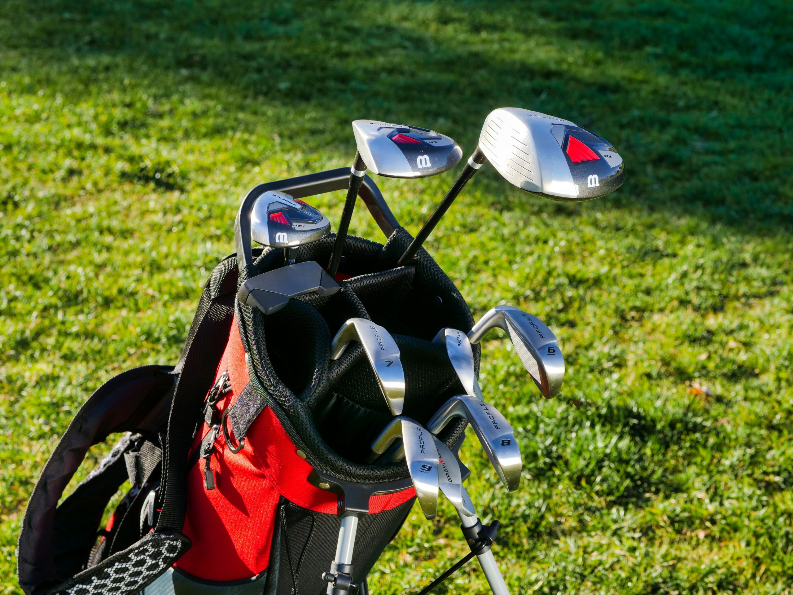 Golf bag on grass with driver and clubs visible, representing equipment choices for golfers looking to reduce a slice